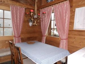 a dining room with a table and pink curtains at Matti-Tinoll in Grimentz