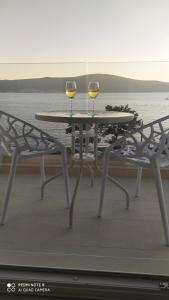 uma mesa com dois copos de vinho numa varanda em Villa Providenca apartments em Tivat