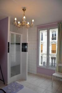 baño con ducha, ventana y lámpara de araña en Hôtel Richard, en París