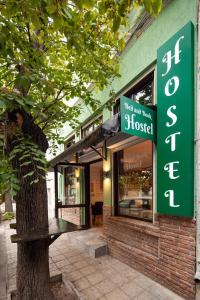 a store with a green sign next to a tree at BED and BOOK hostel in Varna City