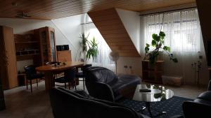 ein Wohnzimmer mit Sofas, einem Tisch und Stühlen in der Unterkunft Nibelungen - Ferienwohnungen - Worms - Apartments in Worms