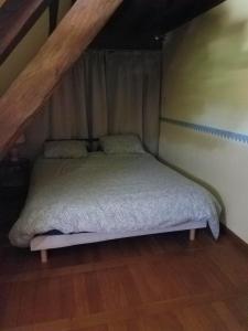een bed in een kleine zolderkamer bij Ferme bressane les Arums in Mervans