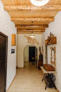 a hallway with a wooden ceiling and a table at Home Kazbegi in Stepantsminda