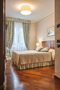 a bedroom with a bed and a large window at Locanda De' Ciompi in Florence
