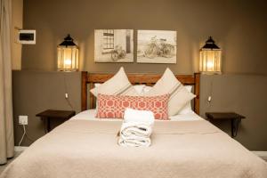 ein Schlafzimmer mit einem großen weißen Bett und Kissen in der Unterkunft Die Herehuis in Beaufort West + 246 Fotos