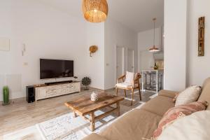 a living room with a couch and a tv at Bajo con Jardin y Piscina cerca de la Playa Dos Dormitorios in Tarifa