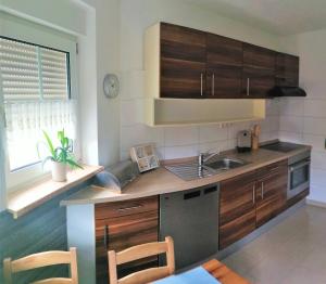 a kitchen with wooden cabinets and a sink at Weidenblick in Callenberg