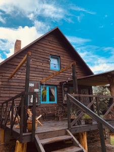 eine Blockhütte mit einer Veranda und einem Fenster in der Unterkunft Domek PoZiomek in Życiny