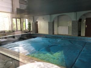 duży basen z niebieską wodą w budynku w obiekcie Haus Gertrud w mieście Schönwald