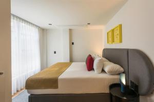 1 dormitorio con 1 cama con almohadas y TV en ParkLife Masaryk, en Ciudad de México