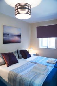 a bedroom with a large bed with a blue blanket at Chestnut Court 2 Bed Apartment FREE Parking WiiFi Smart TV in Wellingborough