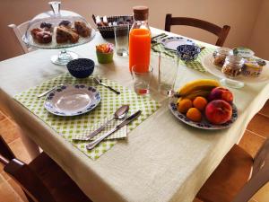 una mesa con una bandeja de fruta y una botella de zumo de naranja en Agriturismo Casale Cerere, en Lacedonia