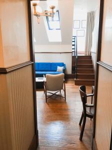 a hallway with a blue couch and a table and chairs at Callas House in Budapest