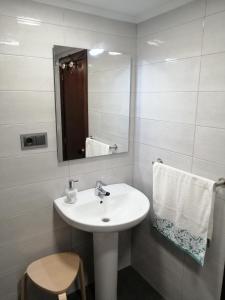 a bathroom with a white sink and a mirror at Apartamento Quety Gijón in Gijón