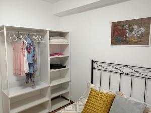 a bedroom with a white closet with clothes at Apartamento Quety Gijón in Gijón