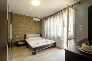 a bedroom with a bed and a large window at Apartment Yanevi in Lozenets
