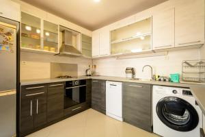 a kitchen with a washing machine and a washer at Apartment Yanevi in Lozenets