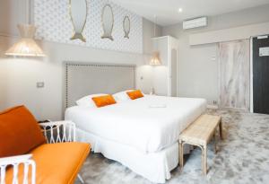 um quarto com uma grande cama branca e um sofá em Grand Hôtel Richelieu em Arcachon