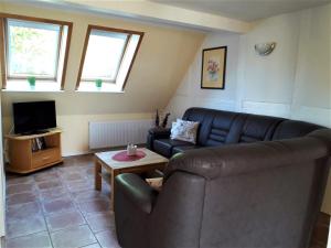 a living room with a couch and a tv at Haus Wiesenblick in Boltenhagen