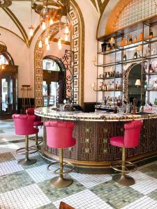 a bar in a restaurant with red chairs at Callas House in Budapest