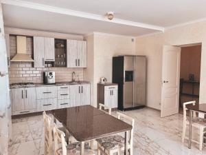 a kitchen with a table and a refrigerator at Starosvetskiy Pan in Myrhorod