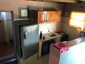 a kitchen with a stainless steel refrigerator and a sink at La Lila in Barra de Valizas