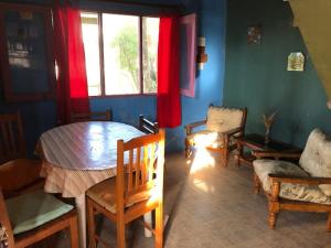 sala de estar con mesa, sillas y ventana en La Lila, en Barra de Valizas