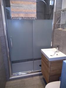 La salle de bains est pourvue d'une douche et d'un lavabo. dans l'établissement La Petite Grange, à Reynès