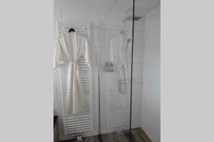 biały szlafrok wiszący w prysznicu w łazience w obiekcie Brabants Genoegen Heeswijk Dinther w mieście Dinther