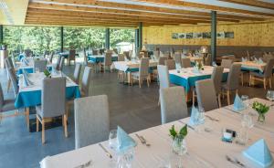 uma sala de jantar com mesas e cadeiras brancas em Gasthof Rabenstein em Sarentino