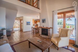 a living room with a fireplace and a table at TRES PINOS Alcanada in Alcudia