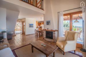 a living room with a fireplace and a table at E314 Tres Pinos by Mallorca Villa Selection in Alcudia