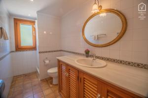 a bathroom with a sink and a toilet and a mirror at E314 Tres Pinos by Mallorca Villa Selection in Alcudia +30 photos