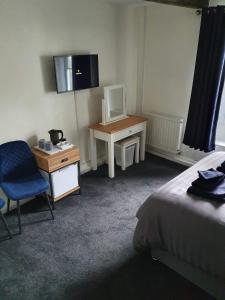 Habitación con cama y escritorio con ordenador. en Red Lion Rooms - Self Check In, en Dalton-in-Furness