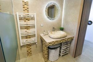 a bathroom with a sink and a mirror at NIKAS APARTMENT in Sibiu