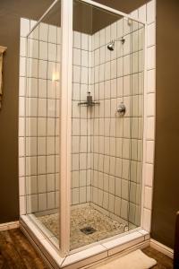 a shower with a glass door in a bathroom at Die Herehuis in Beaufort West