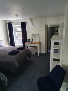 a bedroom with a bed and a desk and a chair at Red Lion Rooms - Self Check In in Dalton in Furness