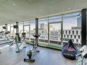 a gym with a view of the city through the windows at Novotel Köln City in Cologne