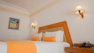 
a bedroom with a bed and a lamp at Hotel Timoulay and Spa Agadir in Agadir
