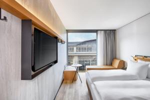 a hotel room with two beds and a flat screen tv at H2 Hotel Leipzig in Leipzig