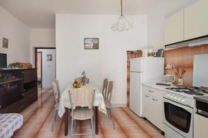 Il comprend une cuisine équipée d'une table avec des chaises et d'un réfrigérateur blanc. dans l'établissement Apartments near beach Babic, à Split