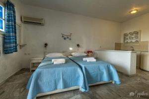 a bedroom with two beds and a tub in it at Lina studios in Kalymnos
