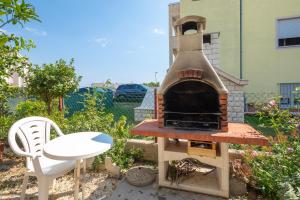 - un four à pizza extérieur avec une table et une chaise dans l'établissement Apartments near beach Babic, à Split