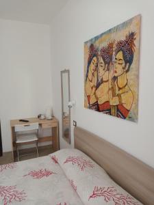 Schlafzimmer mit einem Bett mit Wandgemälde in der Unterkunft Affittacamere Aurora da Nonna Orsola in Villaputzu