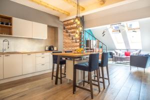 an open kitchen with a wooden table and chairs at Szpitalna 9 Residence in Kraków