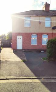 a brick house with a white door and a driveway at Worcester Town Home & Garden in Hindlip