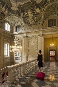 a woman walking down a hallway with a red suitcase at Centro Paolo VI in Brescia