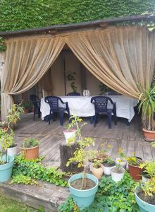 um pátio com uma mesa, cadeiras e vasos de plantas em Home Sweet Home em Chişinău