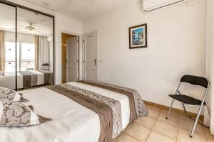 sypialnia z łóżkiem i krzesłem w obiekcie Apartamentos la Mar w mieście Puerto de Santiago +27 zdjęć