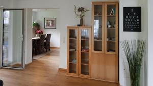 uma sala de estar com um armário de madeira e uma sala de jantar em Villa Piccola em Villach